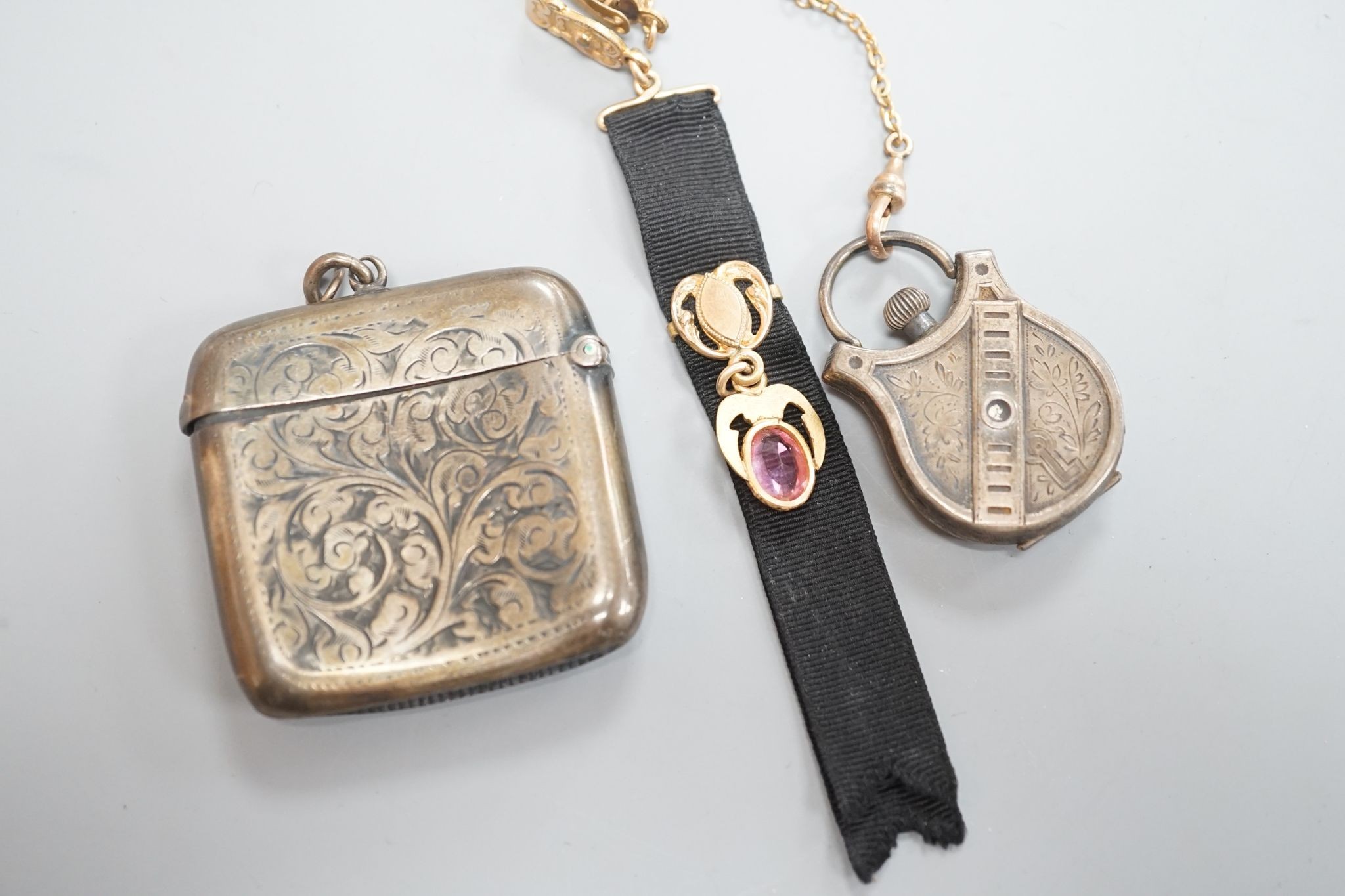 A silver vesta case, 48mm and a white metal cased fob watch, on a black sash suspension.